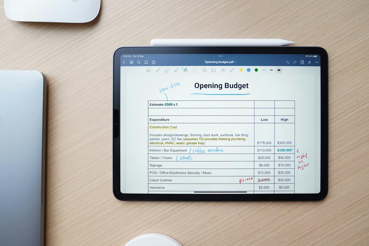 Tablet displaying financial budget on a wooden desk.